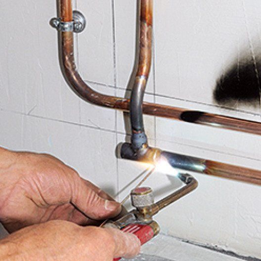 Soudure d'une canalisation en cuivre par un plombier