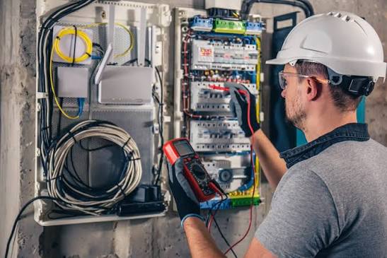 Électricien vérifiant un tableau électrique au multimètre